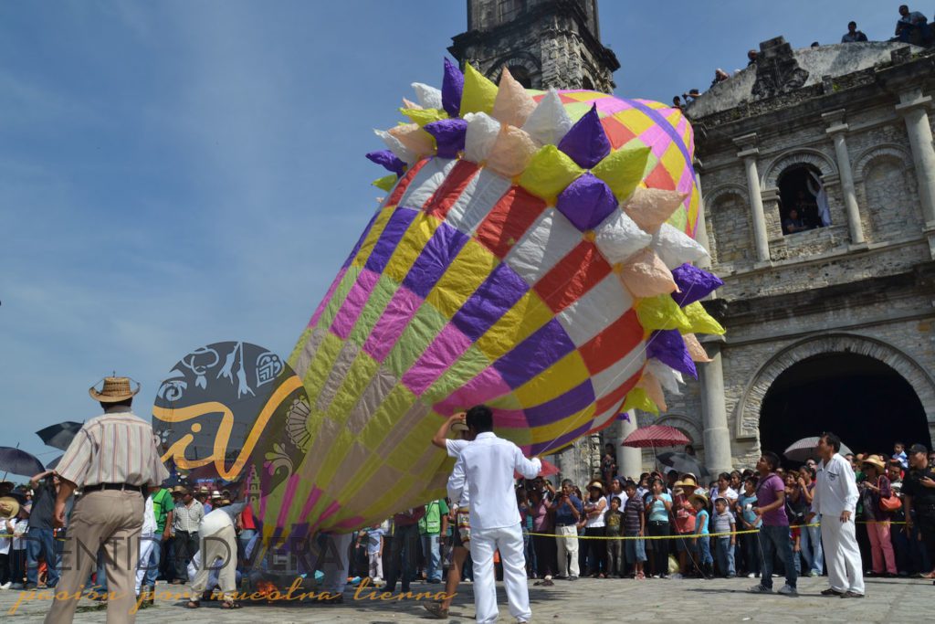 Monumentales globos multicolores son elevados con la ayuda de varias personas.